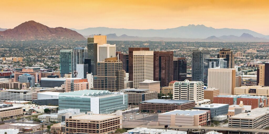 Phoenix skyline at sunset with downtown buildings and mountains in the background, representing Restoration 1 of Avondale's local expertise in mold remediation and restoration services in Phoenix, AZ.